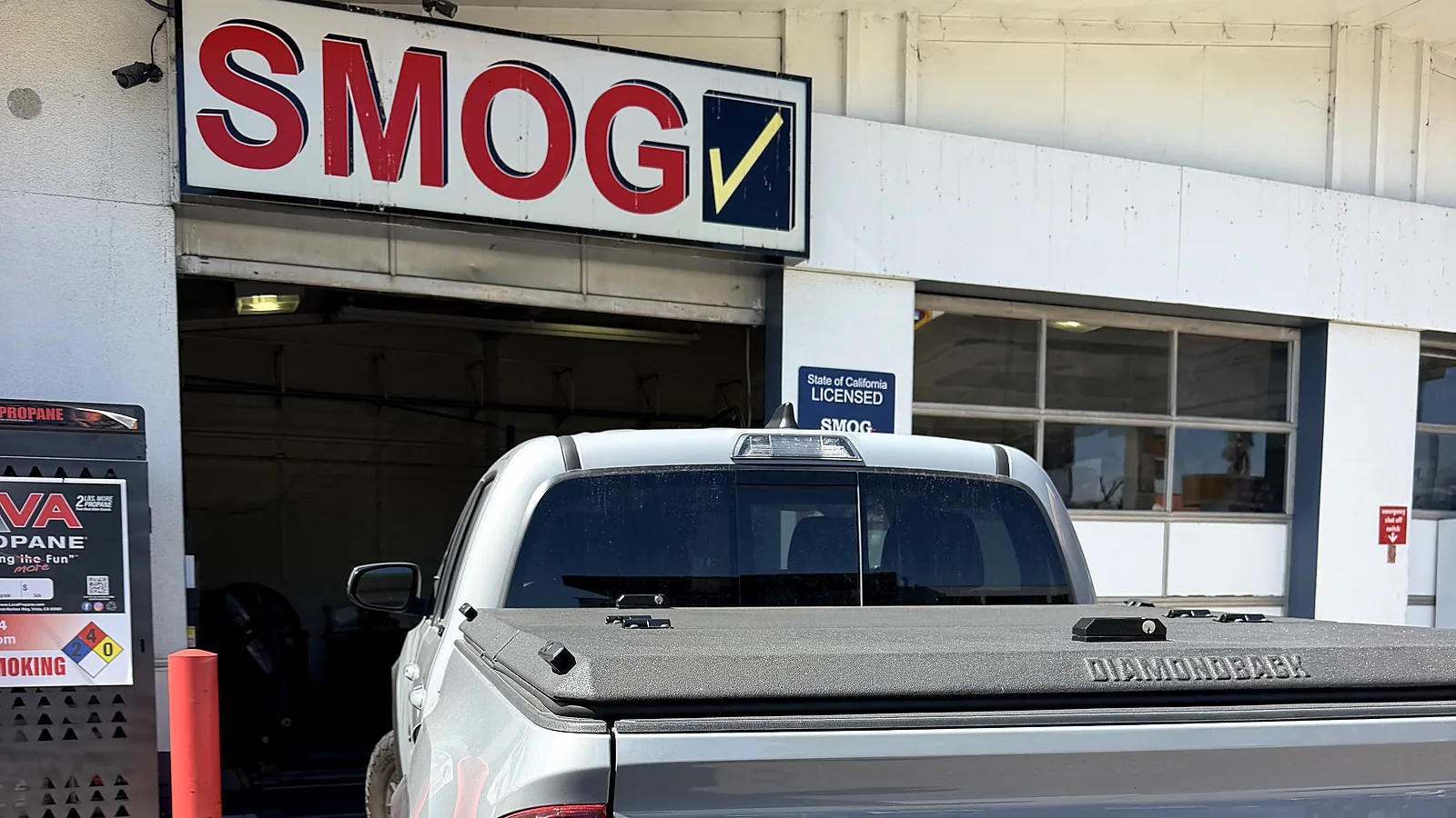 STAR smog check in San Diego, CA: Toyota Tacoma pickup at our F Street station under the Smog sign